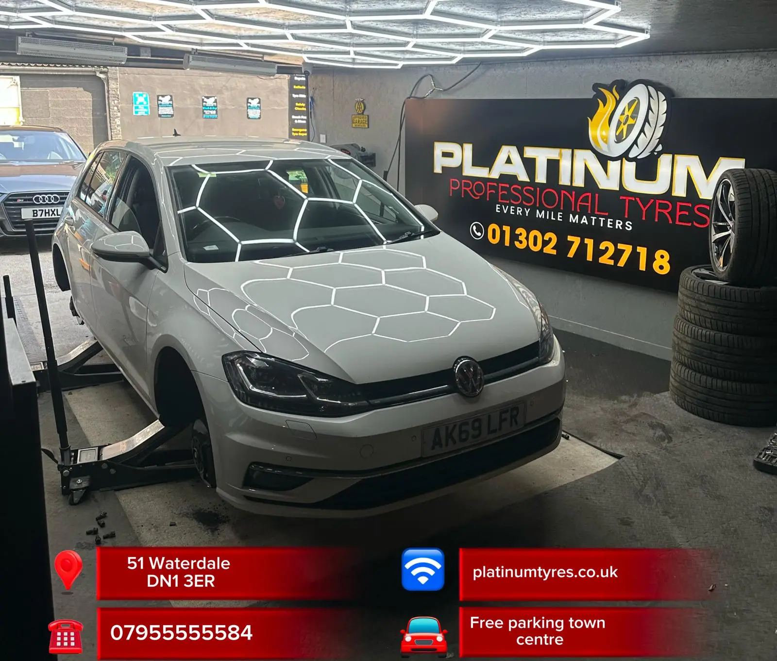 White car inside the Platinum Tyres workshop under hexagonal LED lights